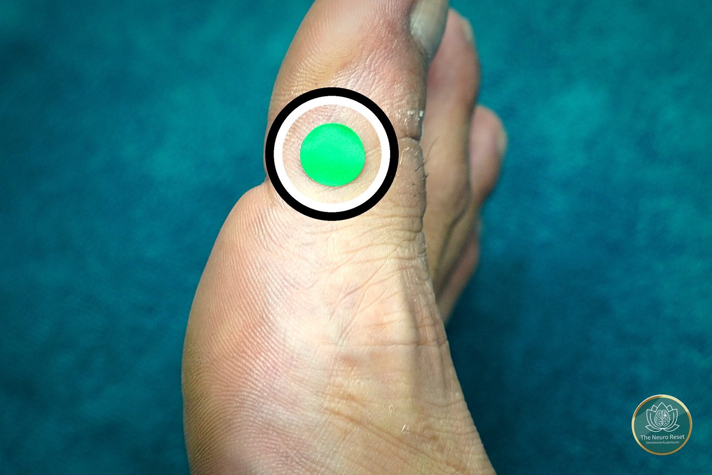 Thumb pressing the top of the big toe, right behind the first joint, on the inner half — the pressure point commonly used for neck stiffness.
