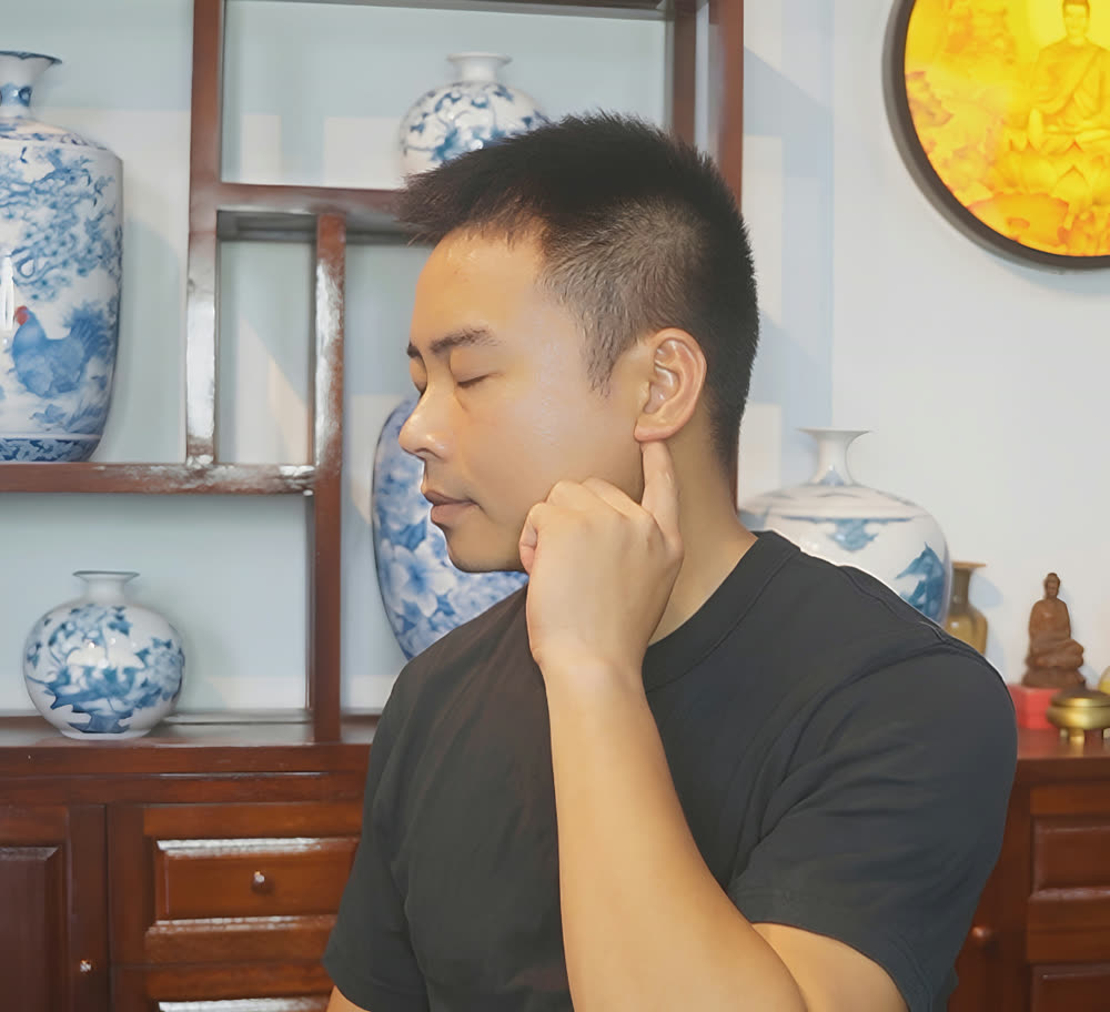 Pressing a point behind the ear at the base of the skull