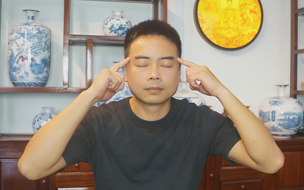 Pressing the points at the temples with both index fingers